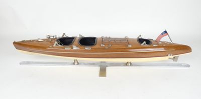 une maquette de bateau en bois sur laquelle sont posées des lunettes de soleil