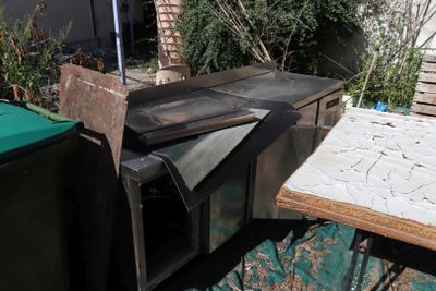 un vieux four posé sur une table dehors, dans la cour