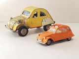 two toy cars sitting next to each other on a white surface
