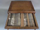 a wooden table with a drawer full of silverware
