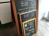 a chalk board with a menu on it in front of a radiator