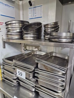 many pans on a metal shelf in a kitchen