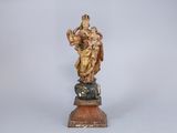 an image of a statue of a woman holding a child on a rock