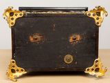 a black and gold chest sitting on top of a wooden table