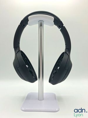 un casque posé sur un support, sur une surface blanche