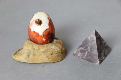 un œuf posé sur un rocher à côté d'une pyramide