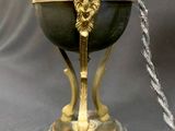 an antique brass and marble lamp with a lion head on the base