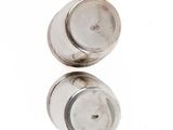 pair of silver salt and pepper shakers on a white surface