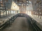 a long row of beds in a building with a lot of windows