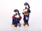 two figurines of a man and a woman sitting on a bench