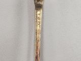 an old spoon with a gold handle on a white surface