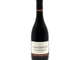 the bottle of wine is sitting on a white surface