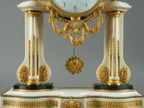 a white and gold clock sitting on top of a table