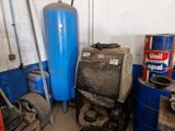 a blue water tank sitting next to a stack of blue barrels