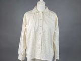 une chemise blanche posée sur un mannequin, sur fond gris