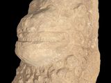 a close up of a stone head on a black background