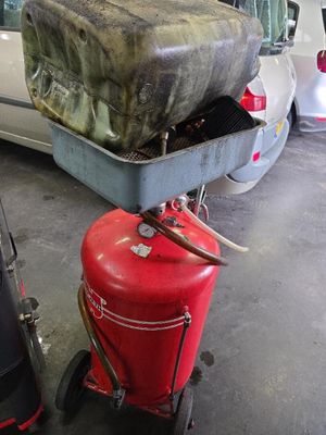 un extincteur rouge posé sur un chariot dans un garage