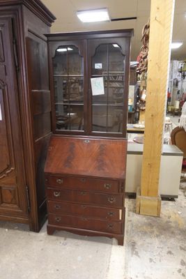 un meuble en bois avec une porte en verre dans une pièce
