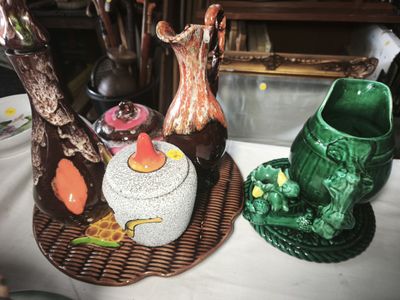 two vases and a bowl on a table next to each other