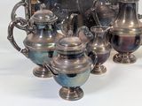 five silver vases sitting next to each other on a table