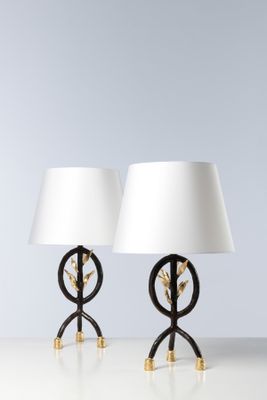 une paire de lampes de table noires et dorées avec des abat-jours blancs