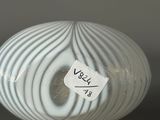 a white vase with a label on it sitting on a table
