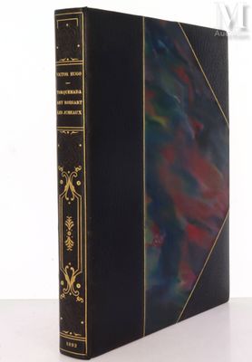 an old book with a black cover and gold trim
