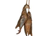 une paire d'oiseaux en bronze perchés sur un fond blanc