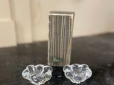 une paire de bougeoirs en verre transparent posés sur une table en marbre noir