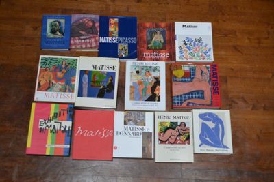 plusieurs livres posés sur une table, devant laquelle se trouve un parquet