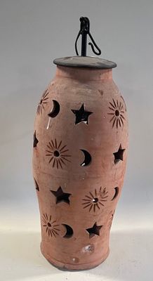 a brown vase with a star and moon design on it