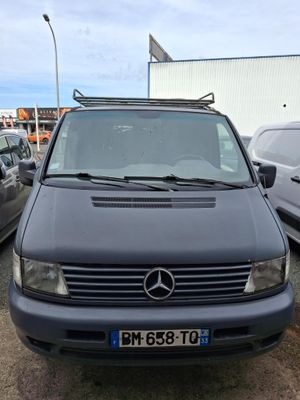 La camionnette est garée sur le parking, à côté d'autres voitures.