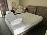 a bed with a white blanket on it in a bedroom