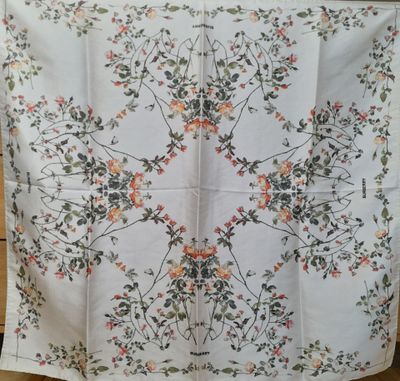 un gros plan sur une nappe blanche ornée de fleurs