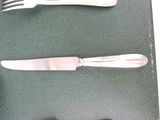 two forks and a knife sitting on a table