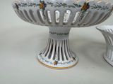 two white vases with flowers on them sitting on a table