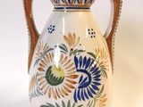 un vase blanc orné d'un motif bleu et jaune
