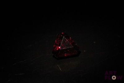 un diamant rouge posé sur une surface noire