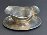 a silver plate with a saucer on it on a black table