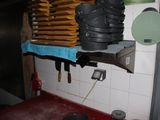 pots and pans are stacked on a shelf in a kitchen