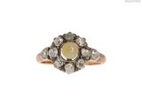 un gros plan d'une bague en diamant et en or sur fond blanc