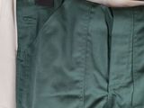 the green pants are hanging on a hanger on the wall