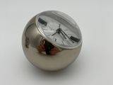 a silver clock sitting on top of a silver ball