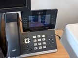 a desk with a phone and a monitor on it