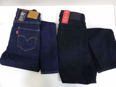 two pairs of levi ' s jeans are sitting on a table