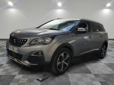 a grey car parked in a garage with a checkered floor