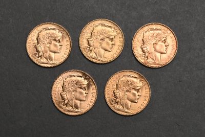 four different types of gold coins on a black surface