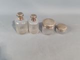 three small glass jars with lids on a white surface