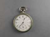 a silver pocket watch with roman numerals on the face