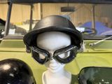 a mannequin wearing a helmet and goggles next to a car